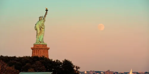 estatua-de-la-libertad-y-luna-llena-al-atardecer-en-la-ciudad-de-nueva-york (1)